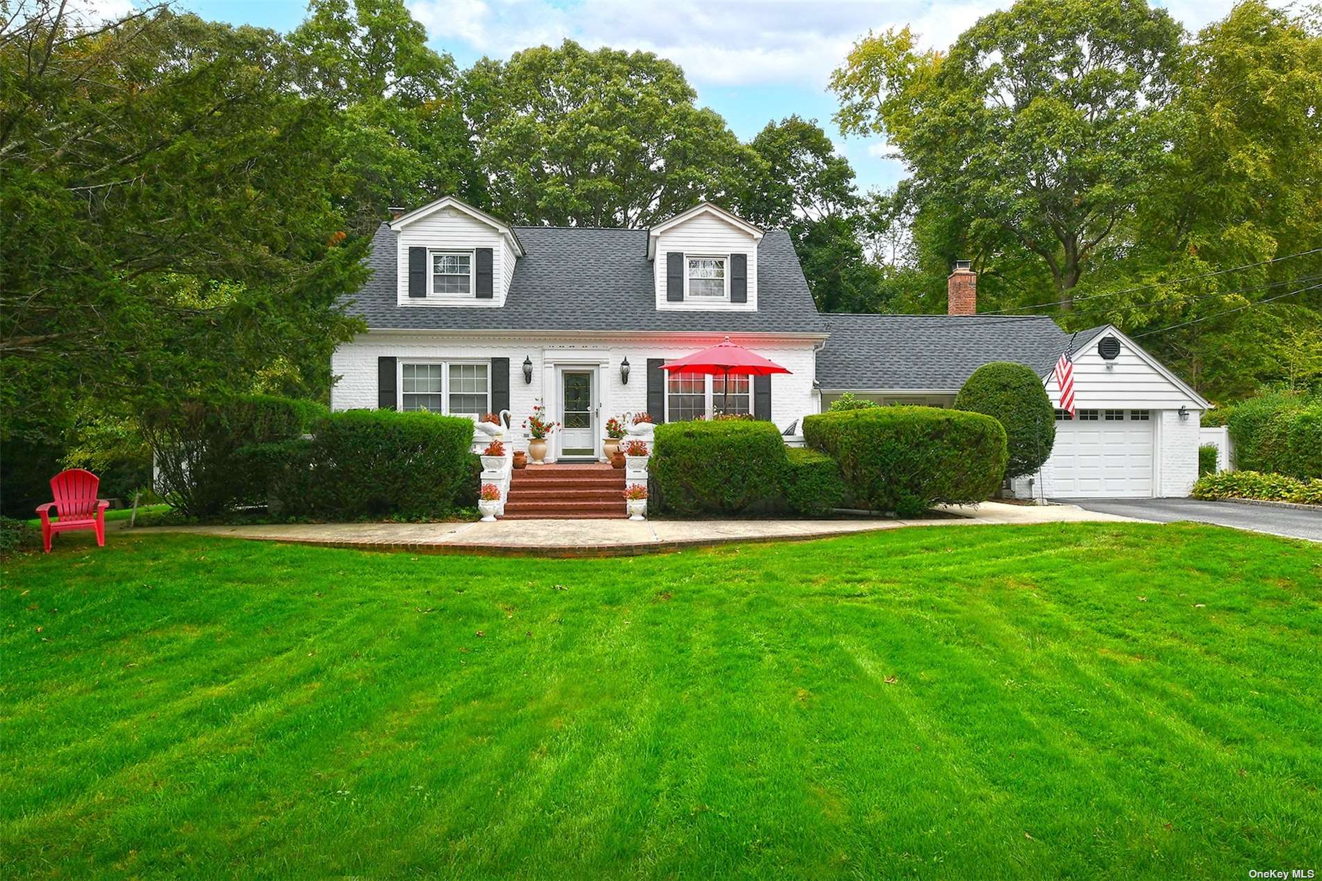 a front view of a house with a yard and trees