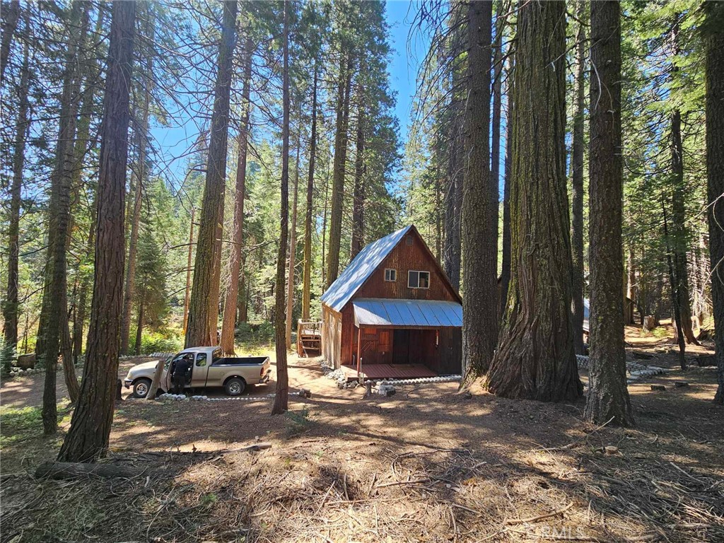 a front view of a house with a yard and tree s