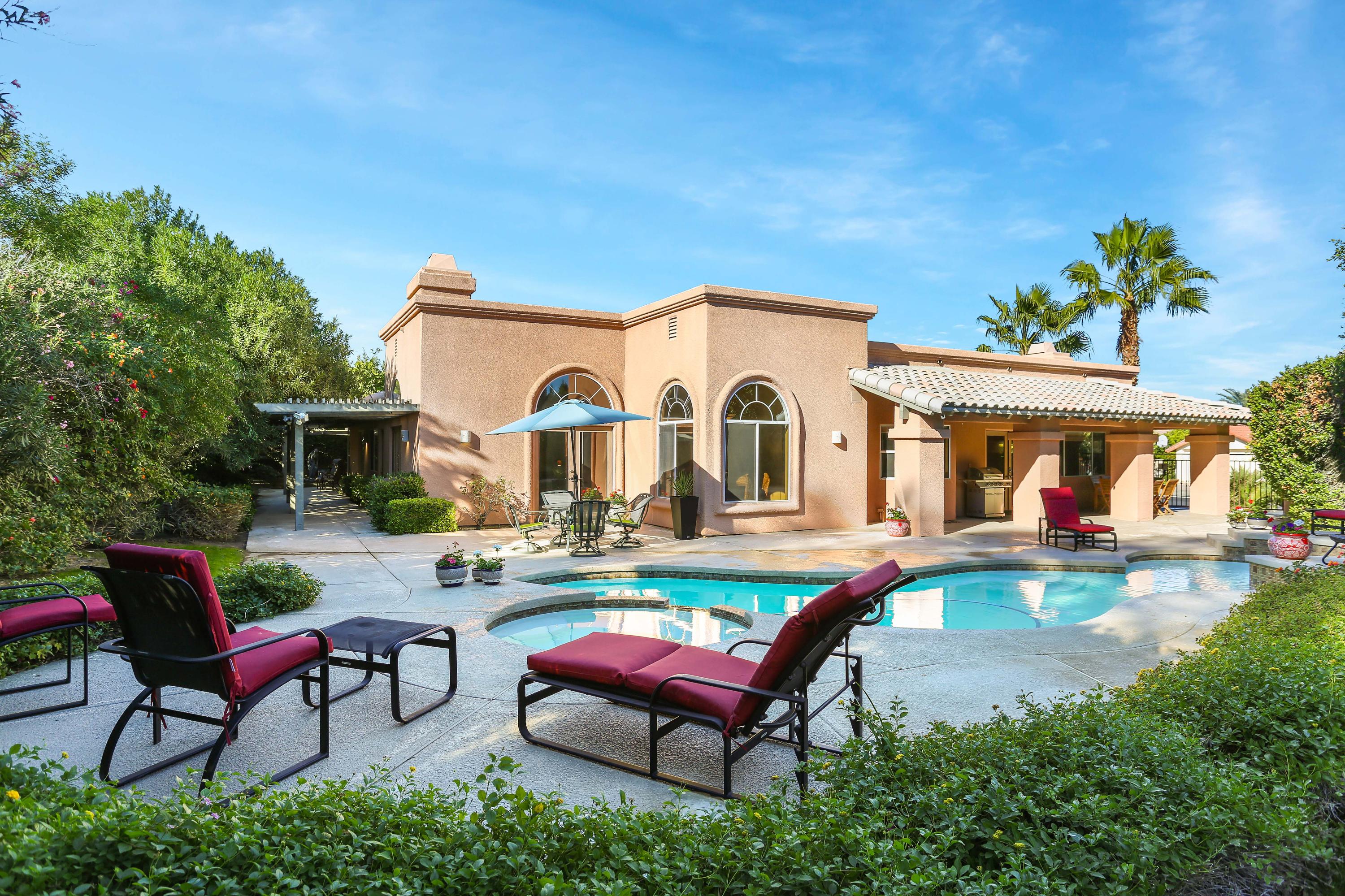 a view of a house with swimming pool and sitting area