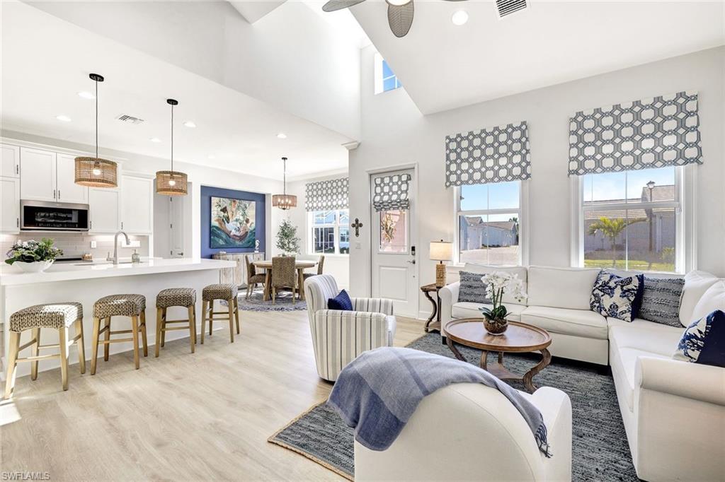 a living room with furniture kitchen view and a wooden floor