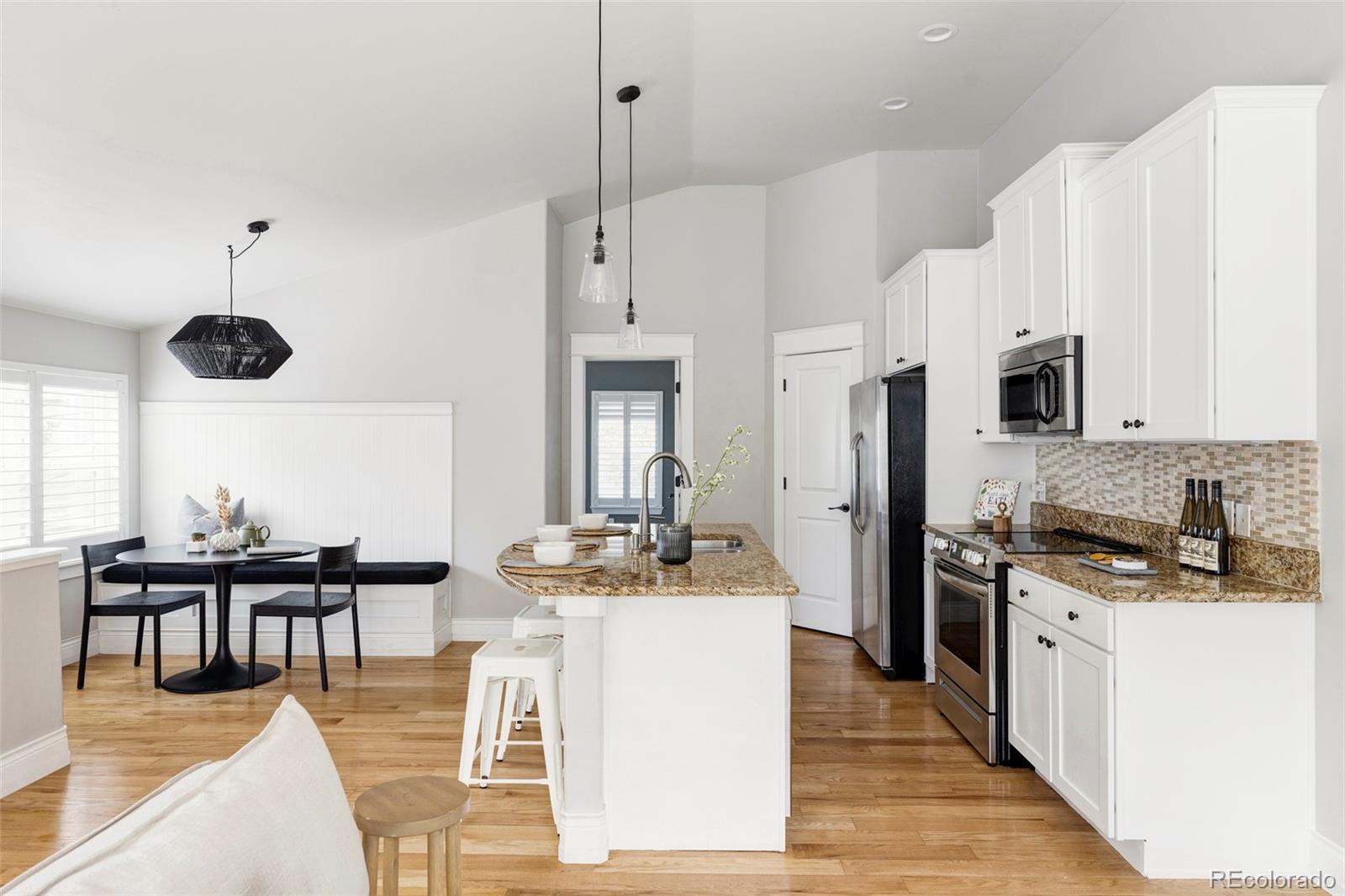 a kitchen with stainless steel appliances kitchen island granite countertop a stove a sink and a refrigerator