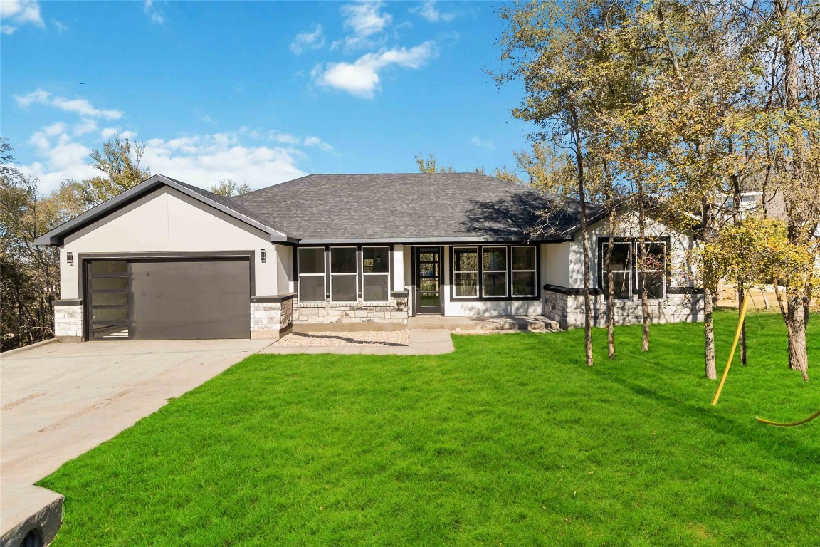 a front view of a house with a yard and trees