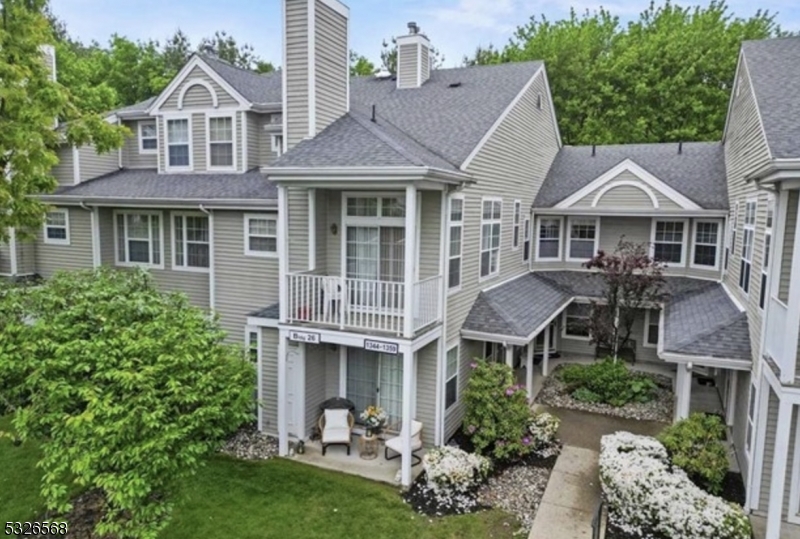 a aerial view of a house with a yard potted plants and a table and chair