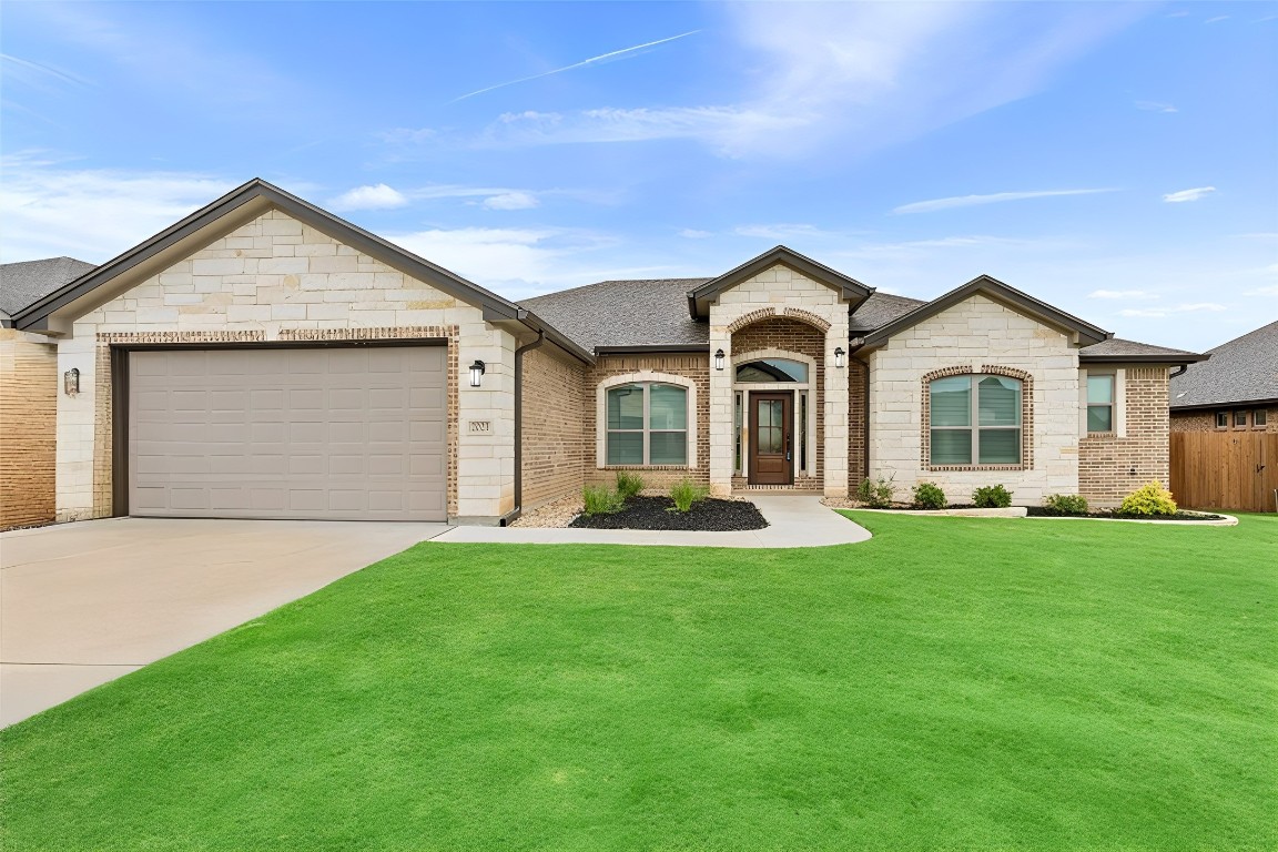 a front view of a house with a garden and yard