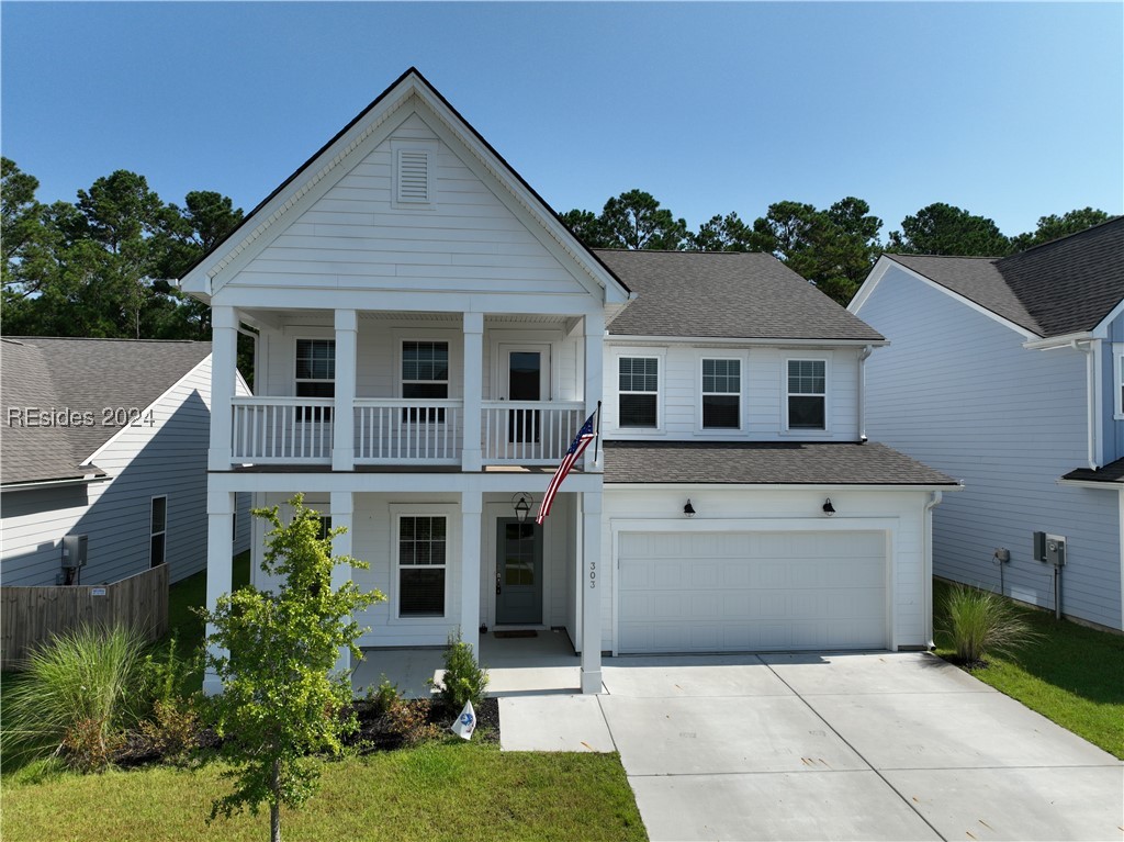 View of front of home with a garage and a balcony