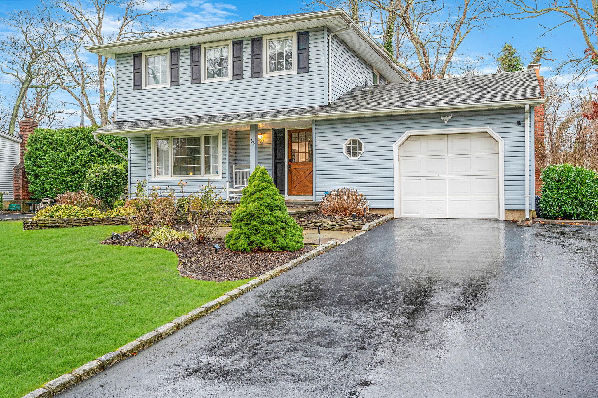 a front view of a house with a yard and garage