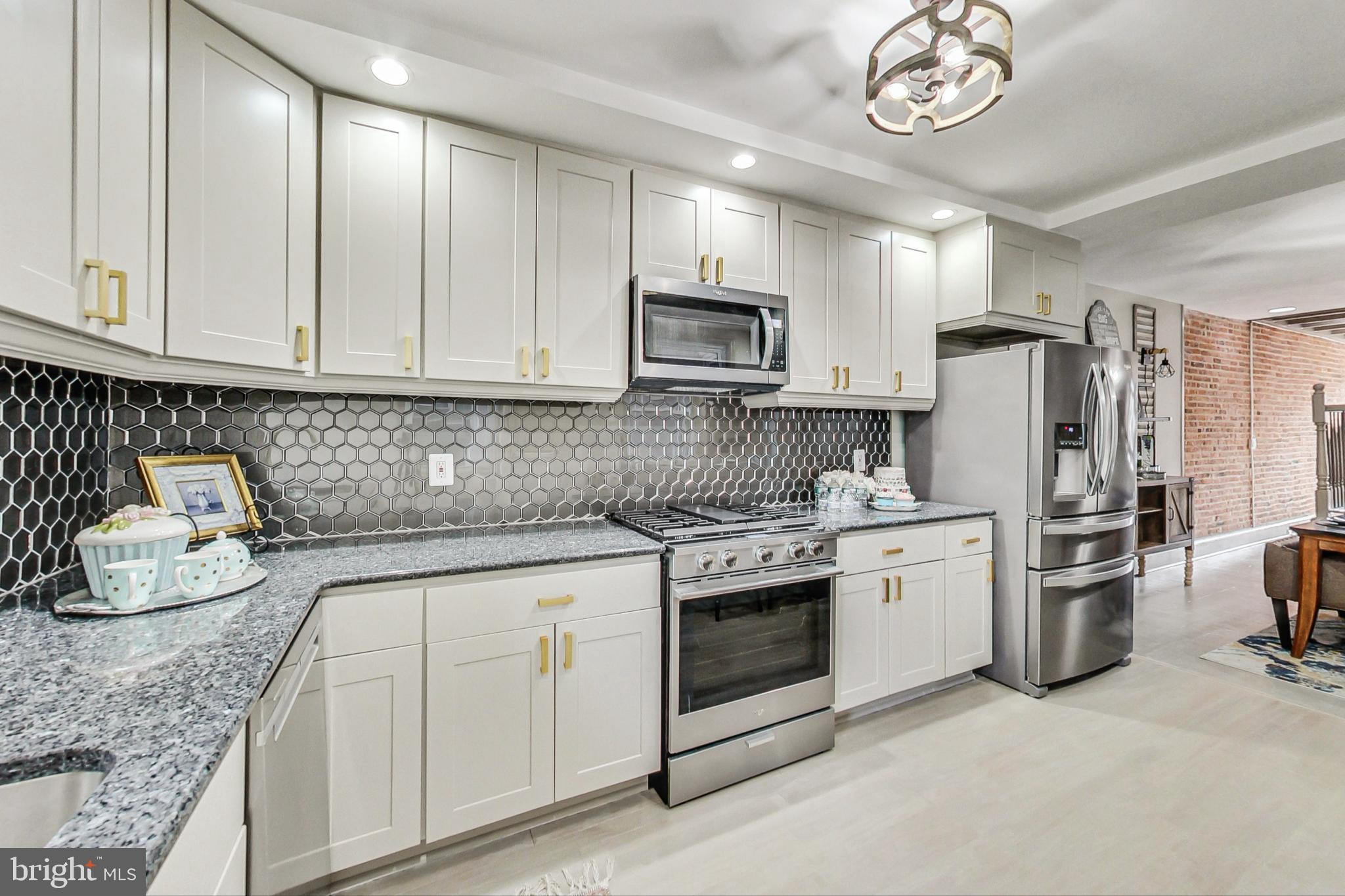 a kitchen with stainless steel appliances granite countertop a stove a sink and a refrigerator