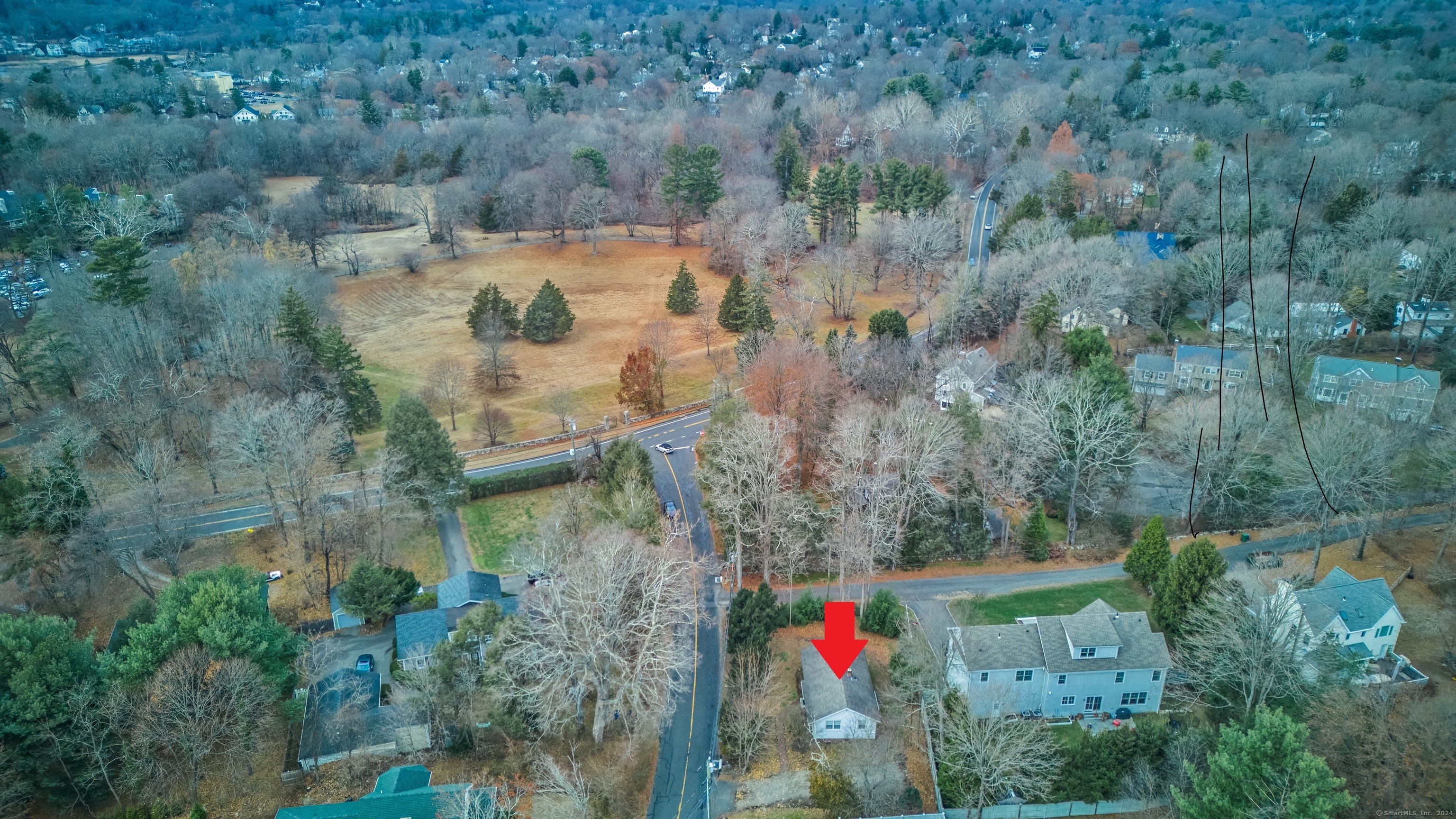 an aerial view of residential house with outdoor space and trees all around