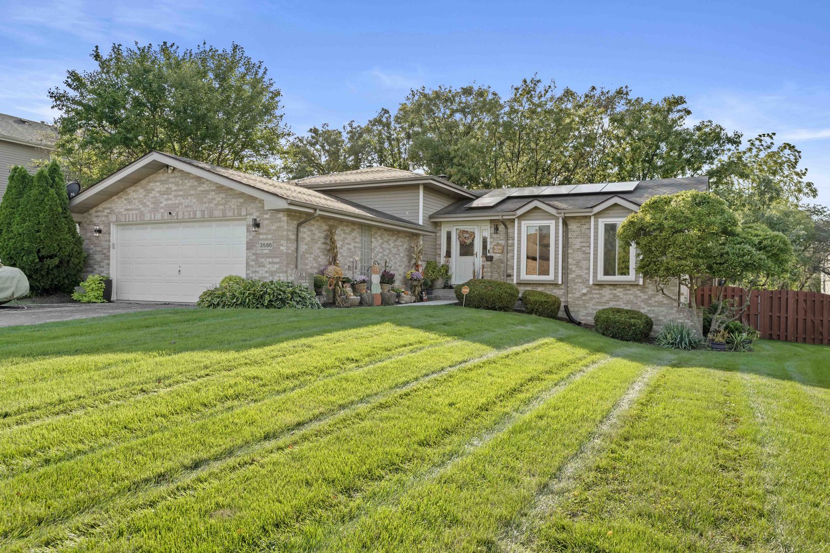 a view of a house with a yard and large trees