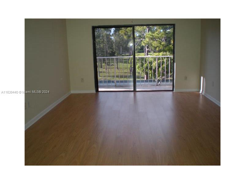 a open hall with wooden floor and floor to ceiling window