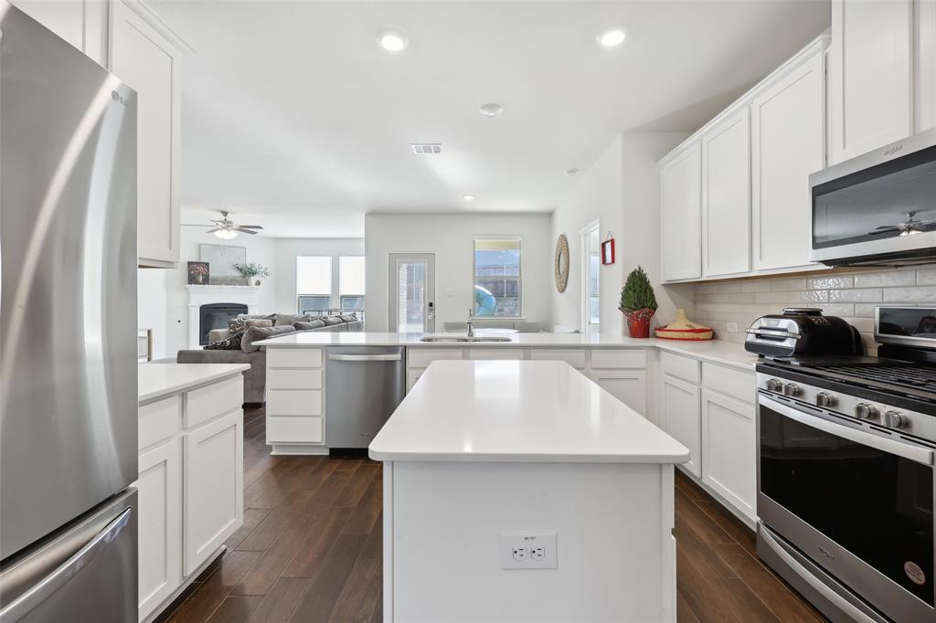 a kitchen with white cabinets appliances and sink