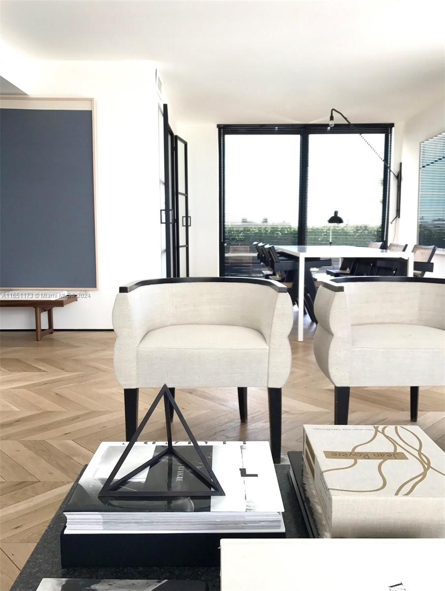 a living room with furniture and floor to ceiling window