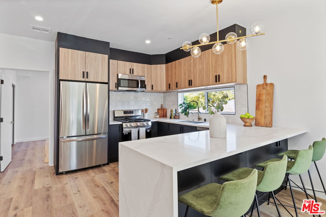 a kitchen with kitchen island a counter top space appliances and cabinets