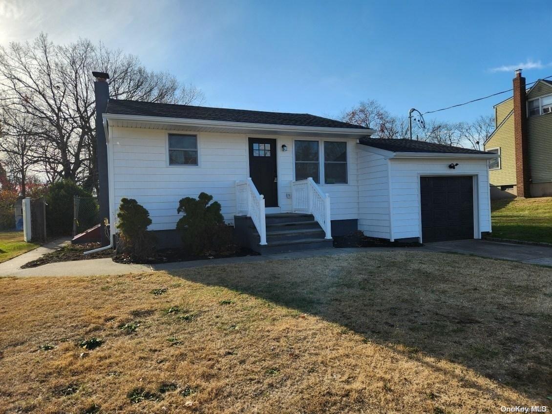 View of front of property featuring a front lawn and a one car attached garage