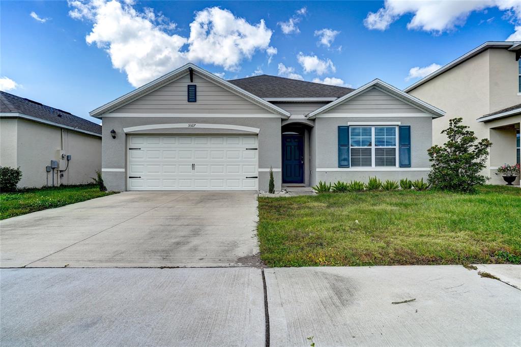 a front view of a house with a yard and garage