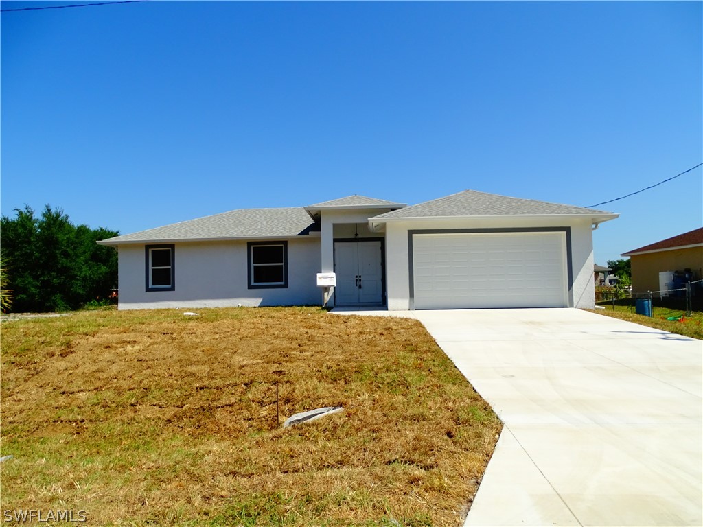 a front view of a house with yard and parking