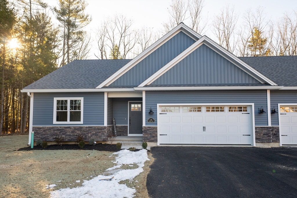 a view of house with a yard and garage