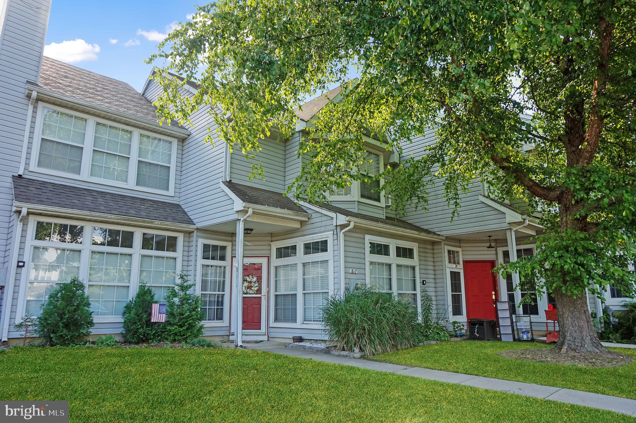 a front view of a house with a yard and green space