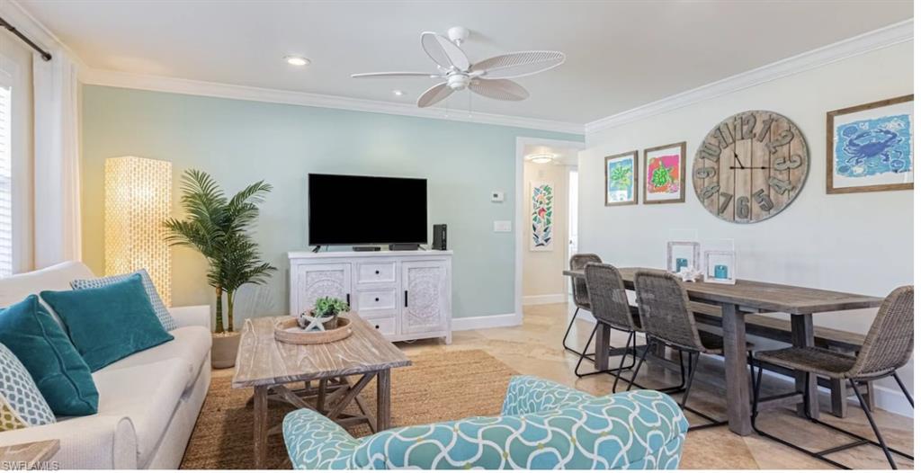 a living room with furniture a flat screen tv and kitchen view