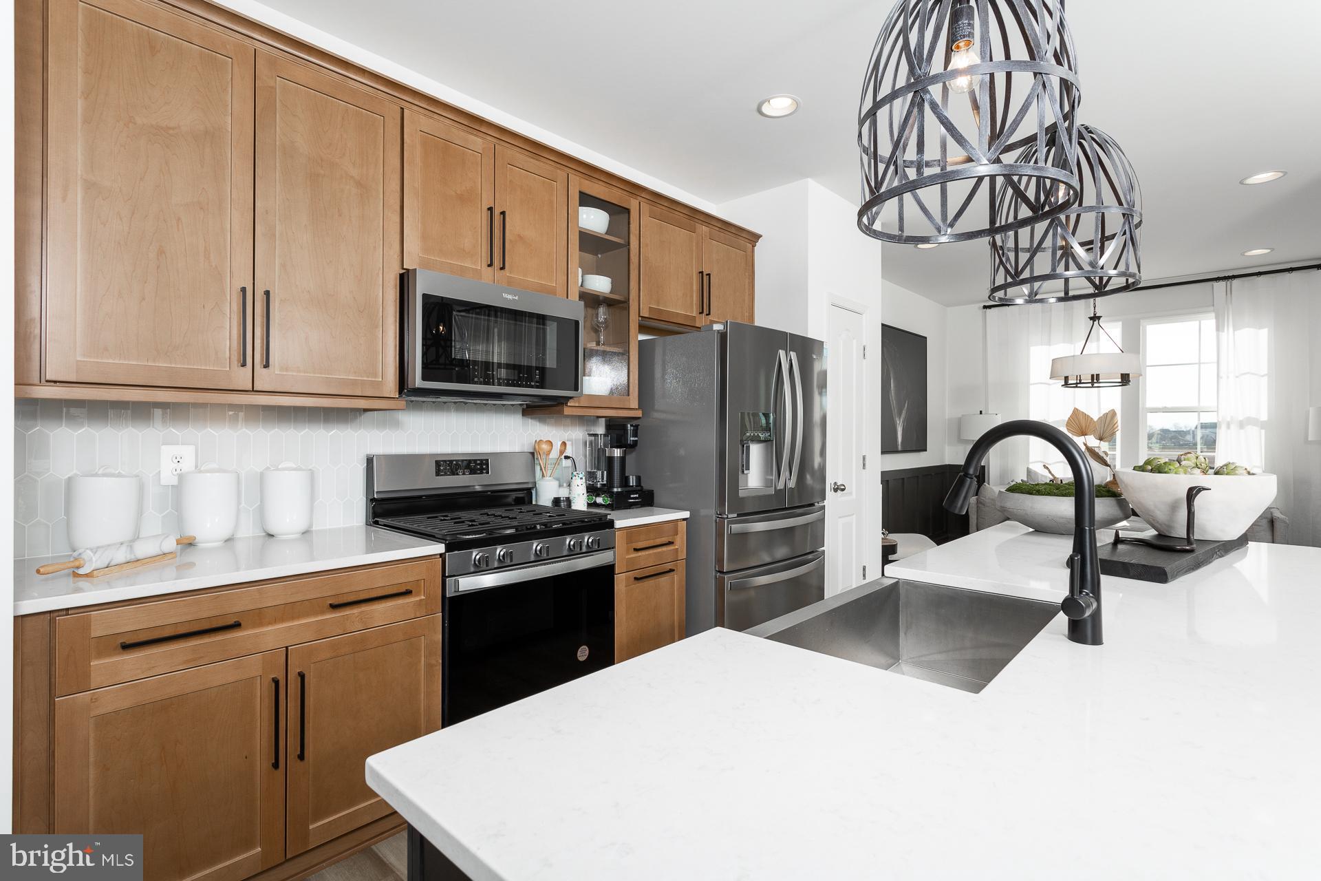 a kitchen with stainless steel appliances a stove refrigerator sink and cabinets