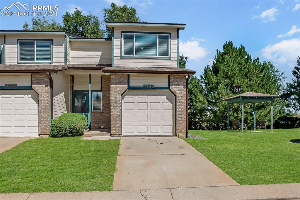 View of front of property featuring a front yard and a garage