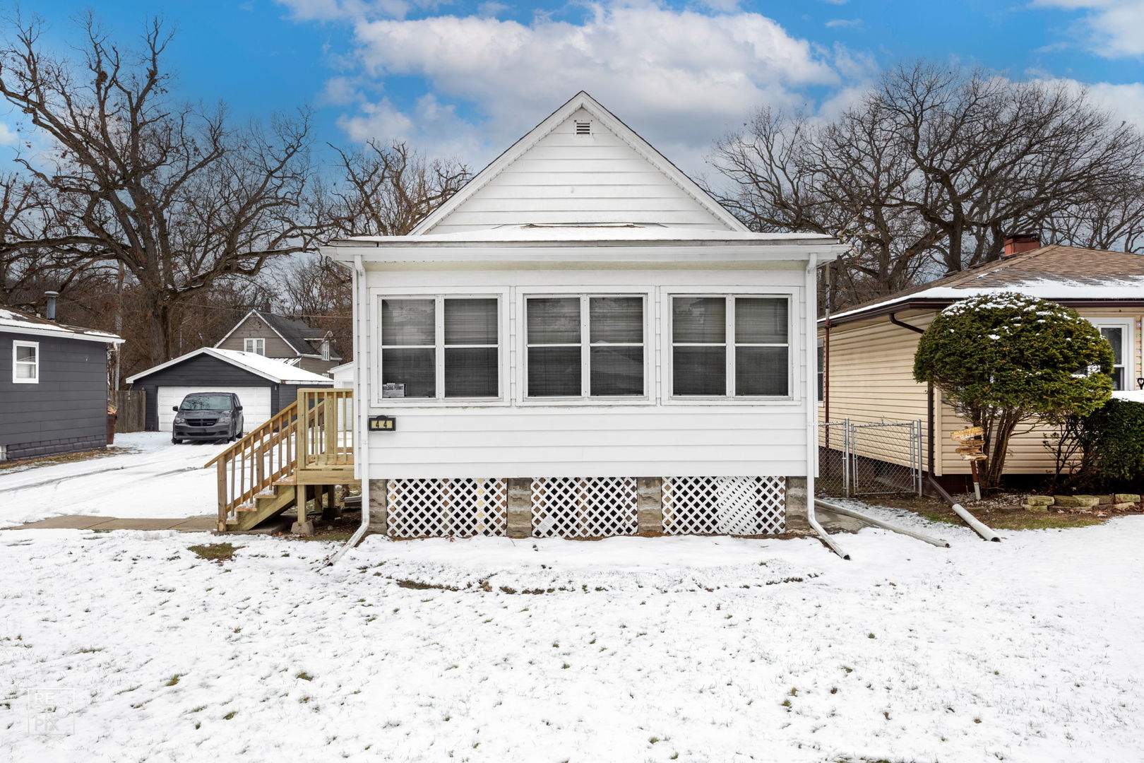 a front view of a house with a yard covered in snow