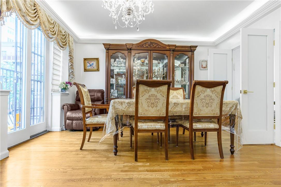 Dining area with light hardwood / wood-style floors, crown molding, and a chandelier