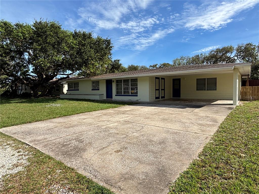 a front view of house with yard and trees in the background