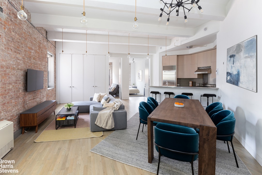 a living room with furniture a flat screen tv and kitchen view