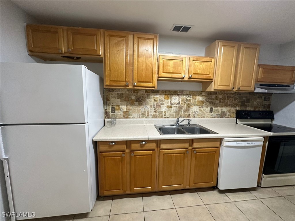 a kitchen with a sink a stove and a refrigerator