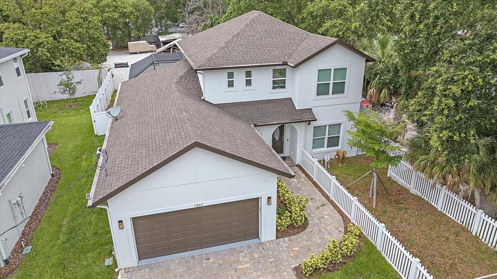 a aerial view of a house next to a yard with large trees