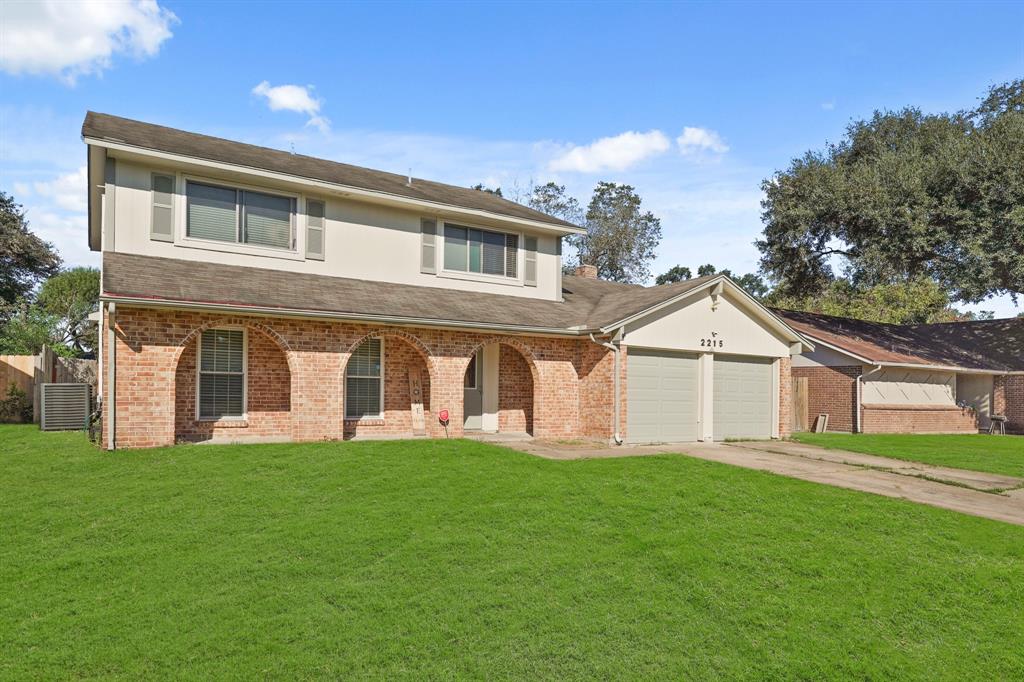 a front view of a house with a yard and trees