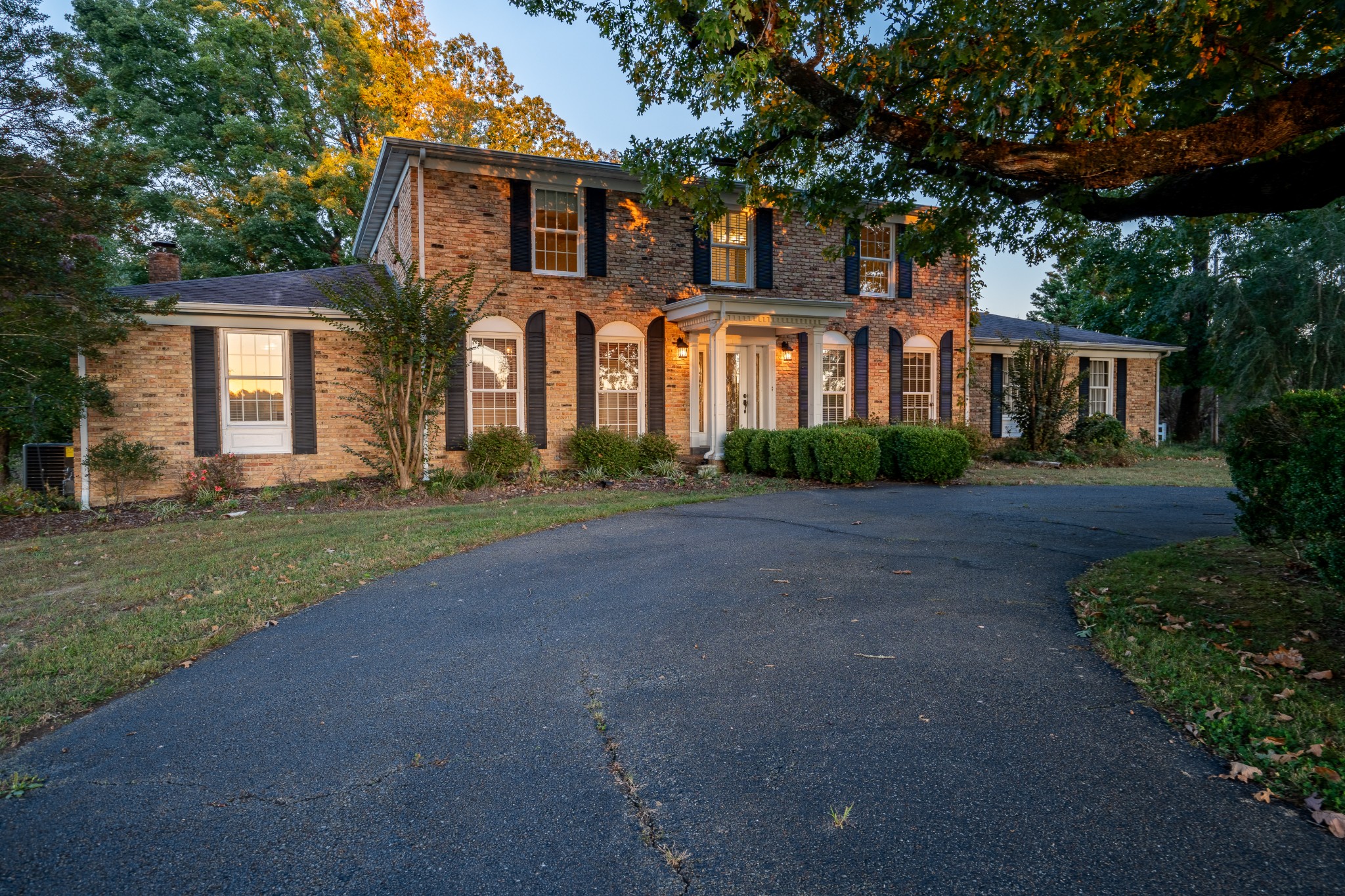 a front view of a house with a yard and trees