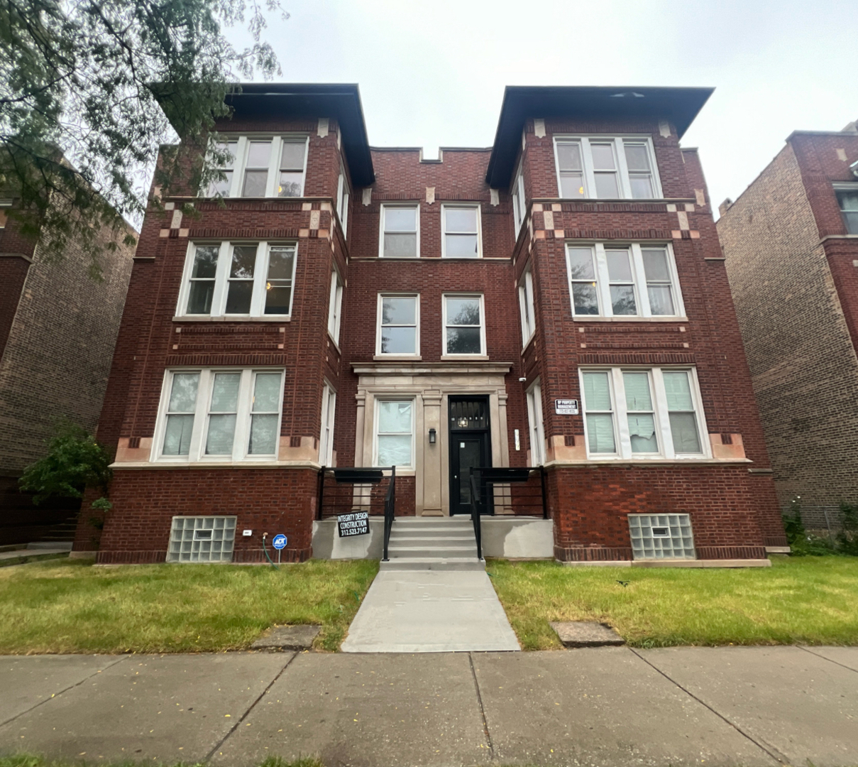 a front view of a multi story residential apartment building with a yard