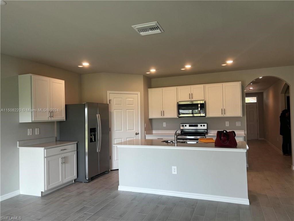 a kitchen with stainless steel appliances a refrigerator sink and microwave