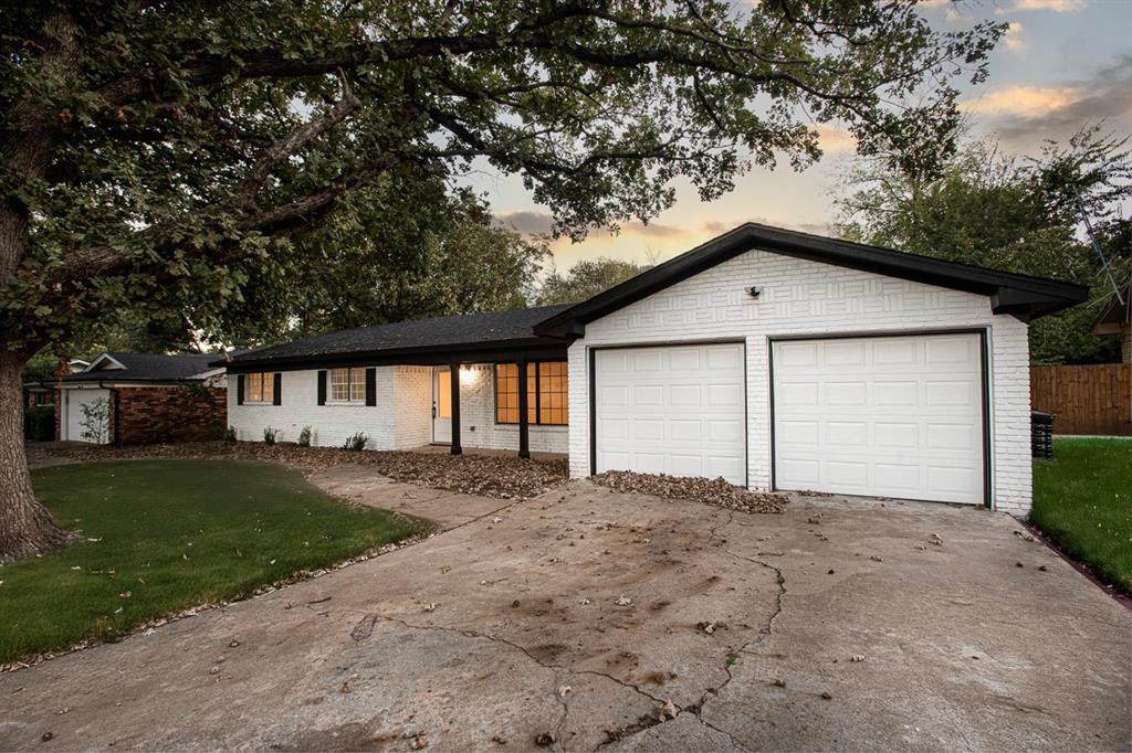 a view of a house with a yard and large tree