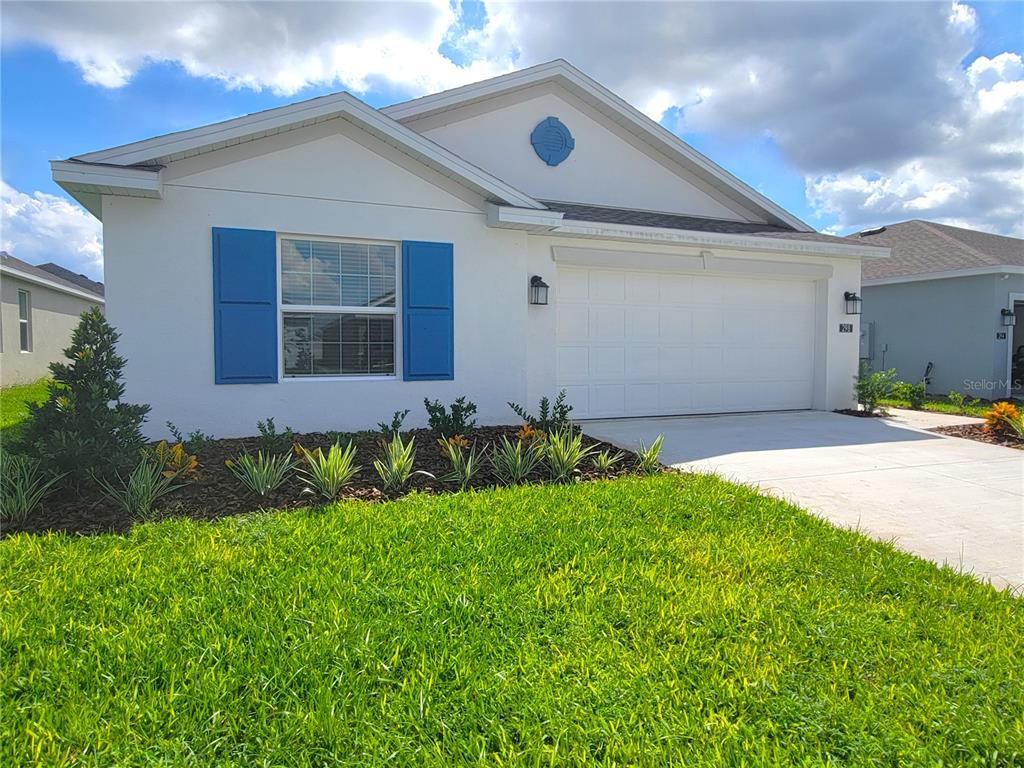 a front view of a house with a yard and garage