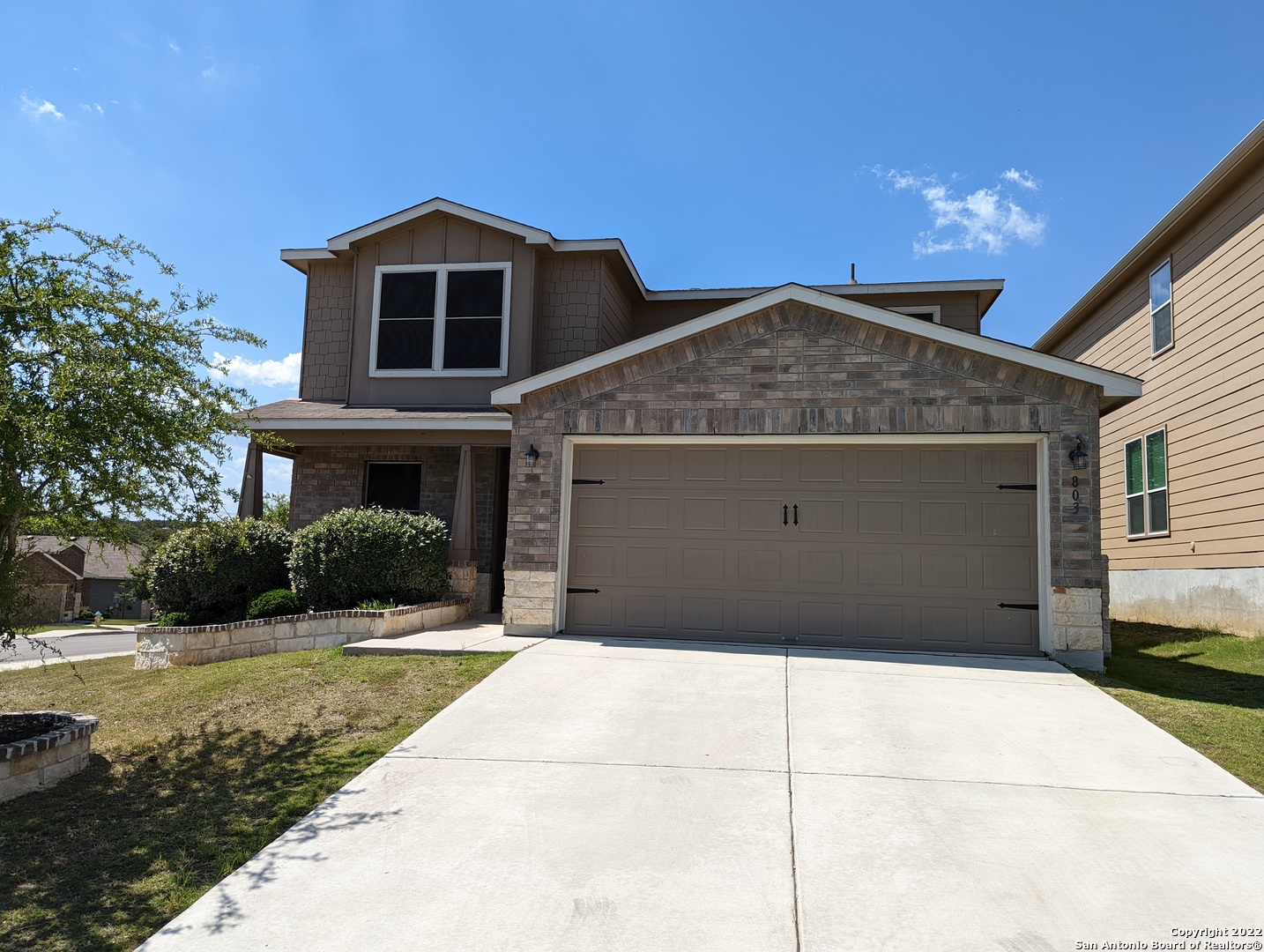 a front view of a house with a yard and garage