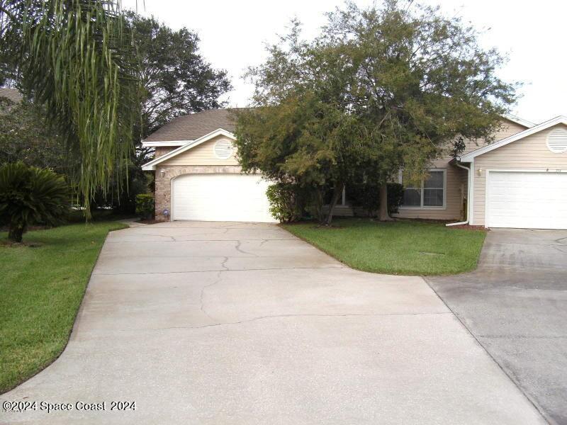 a view of white house with a yard and garage