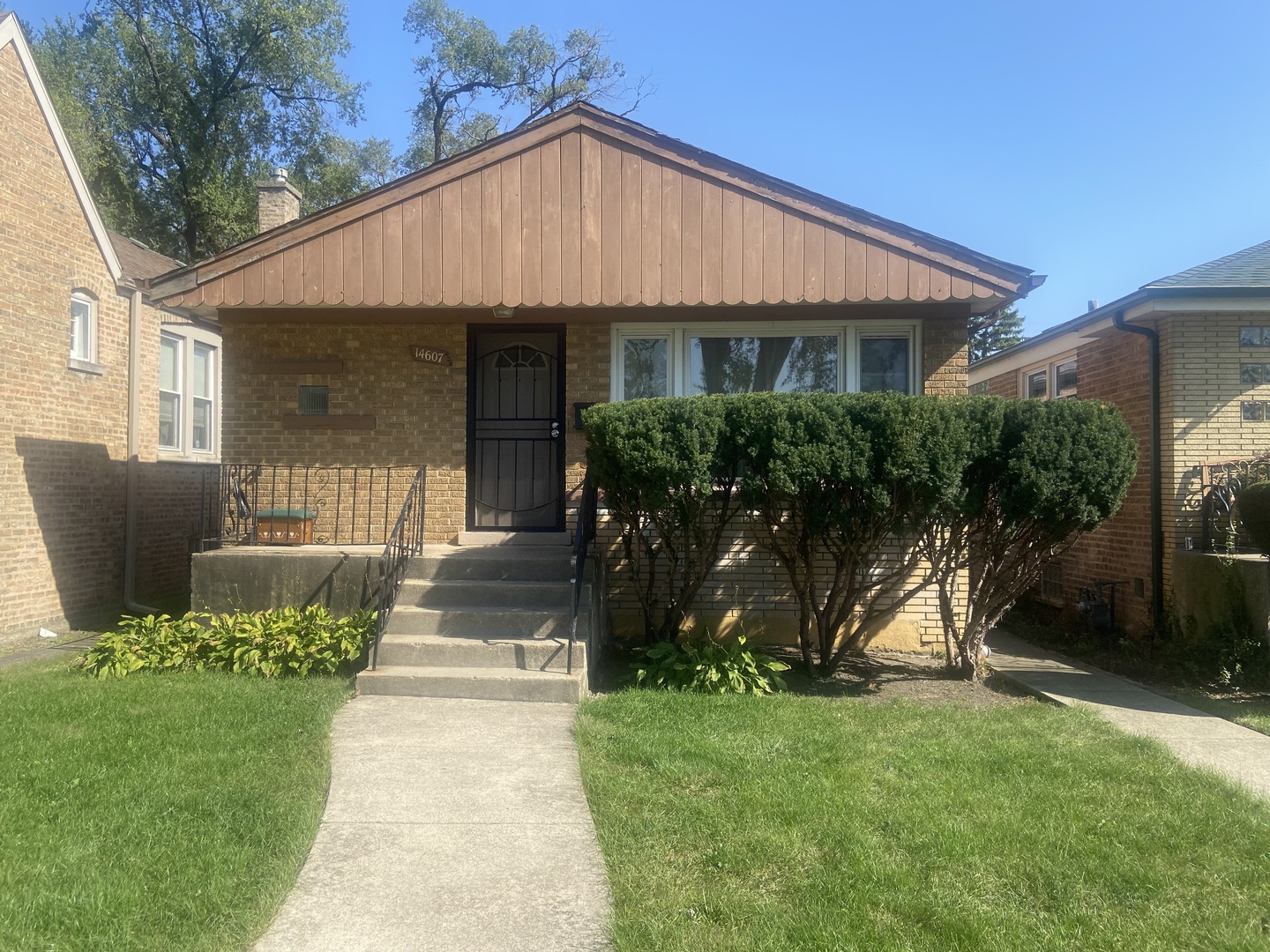 a front view of a house with a yard and potted plants