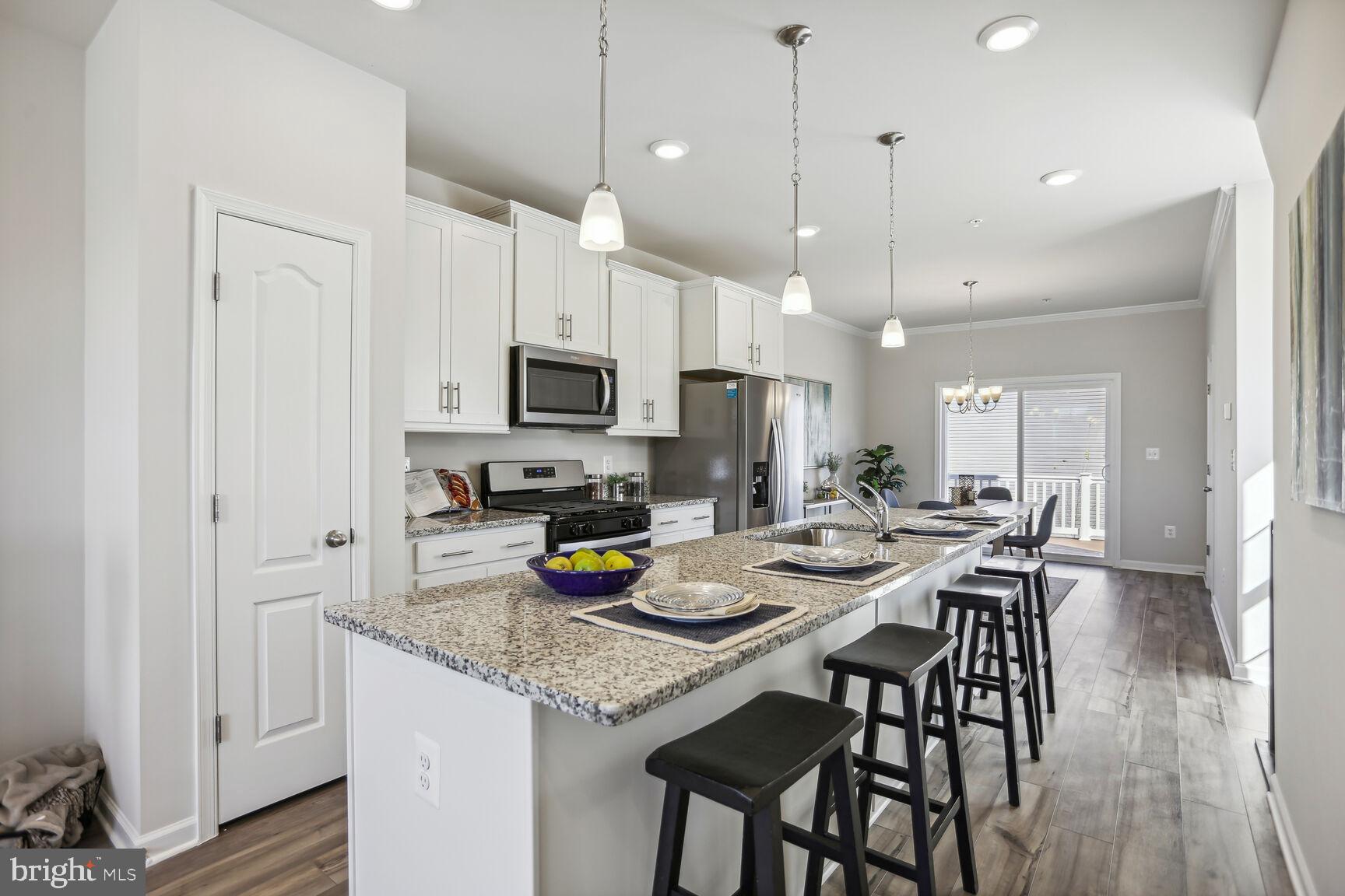 a kitchen with a sink a stove a dining table and chairs