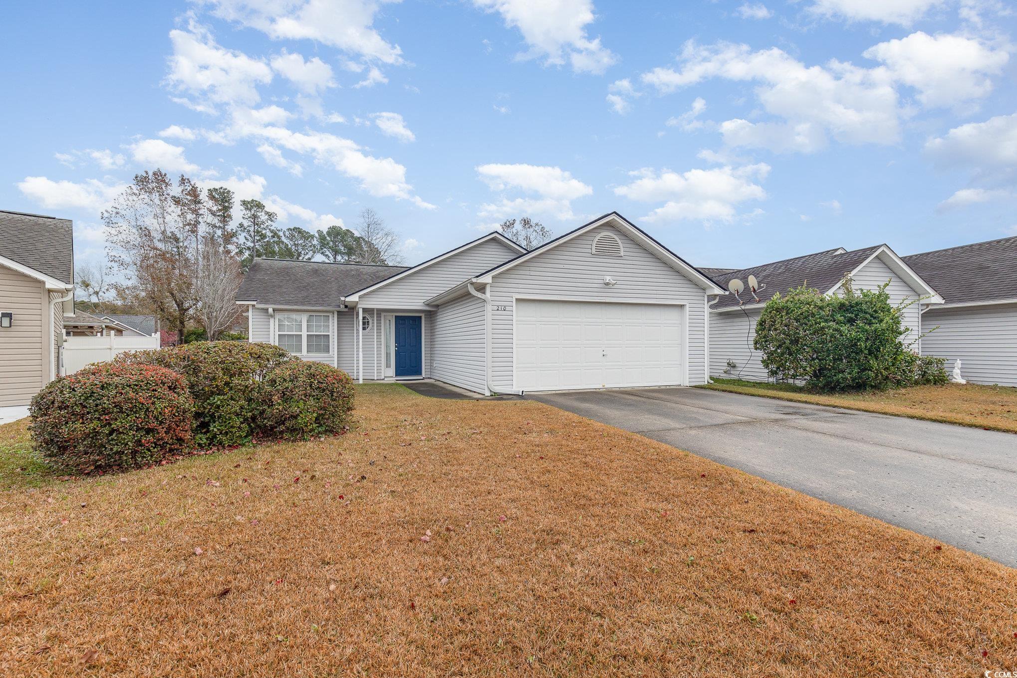 Single story home with a garage and a front lawn