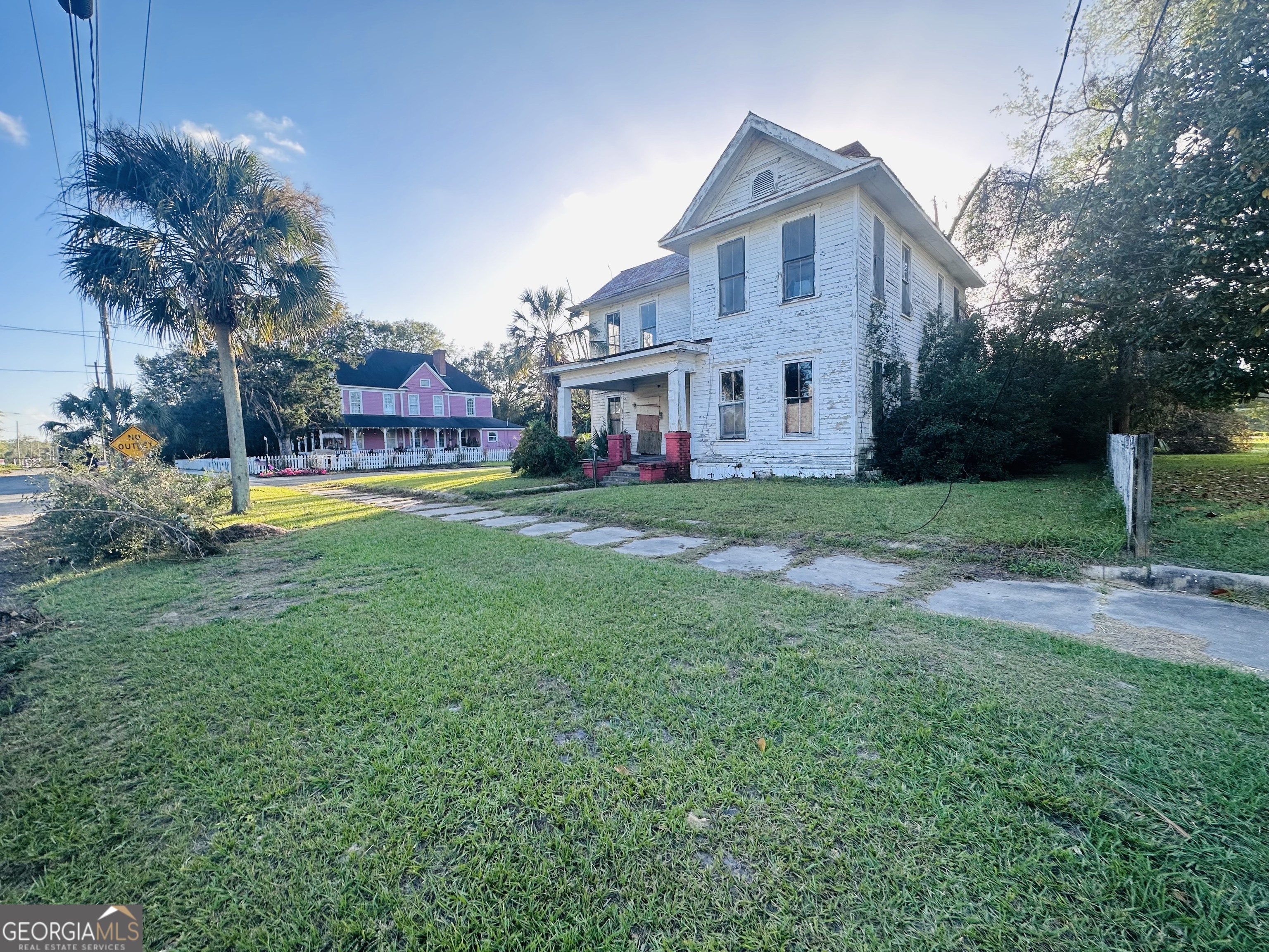 a front view of house with yard and trees in the background