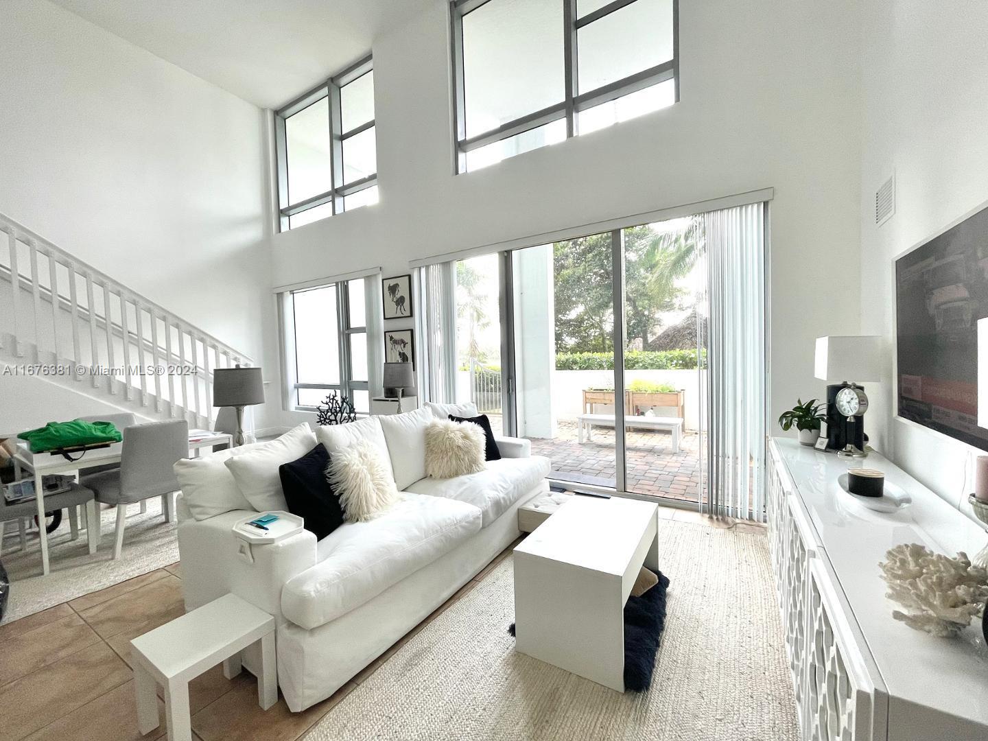 a living room with furniture large window and a flat screen tv