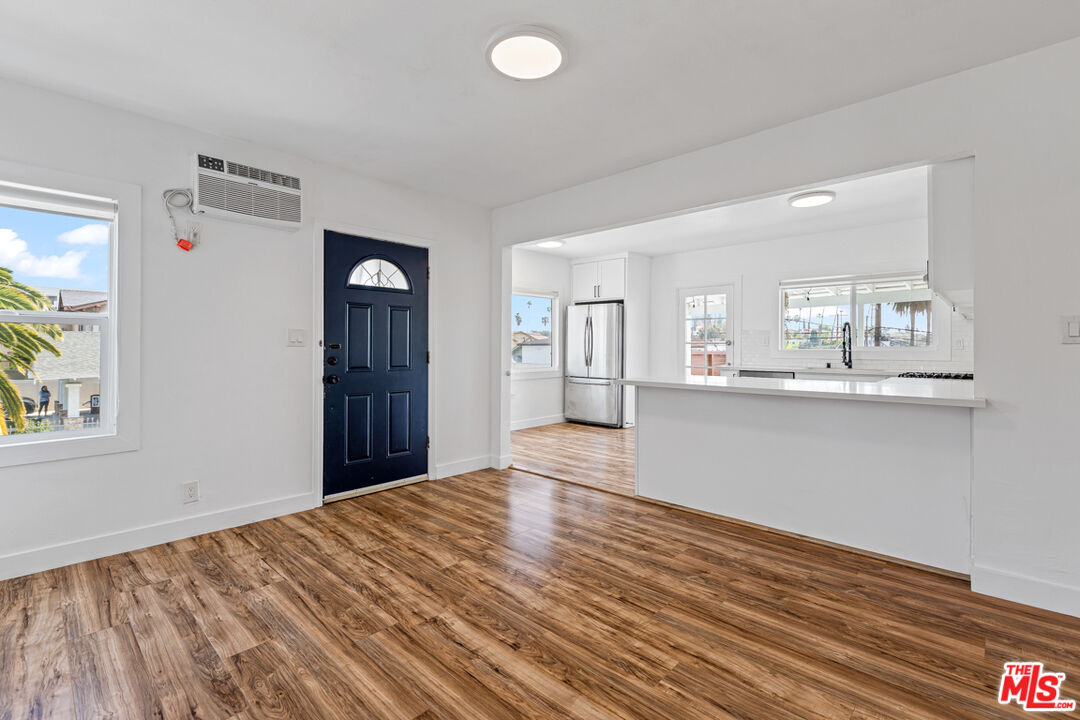 a view of a kitchen with wooden floor and a window