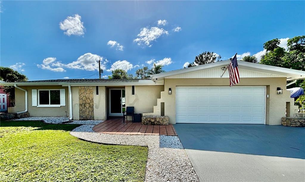 Ranch-style home with a front yard and a garage