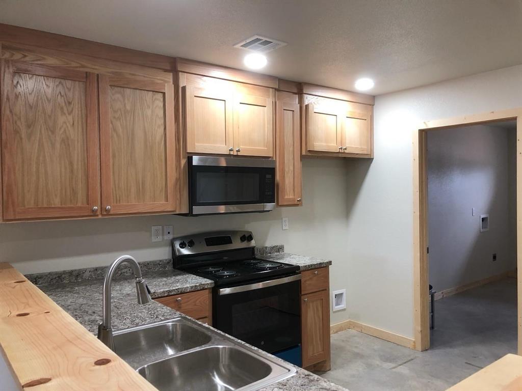 a kitchen with stainless steel appliances granite countertop a sink stove and microwave