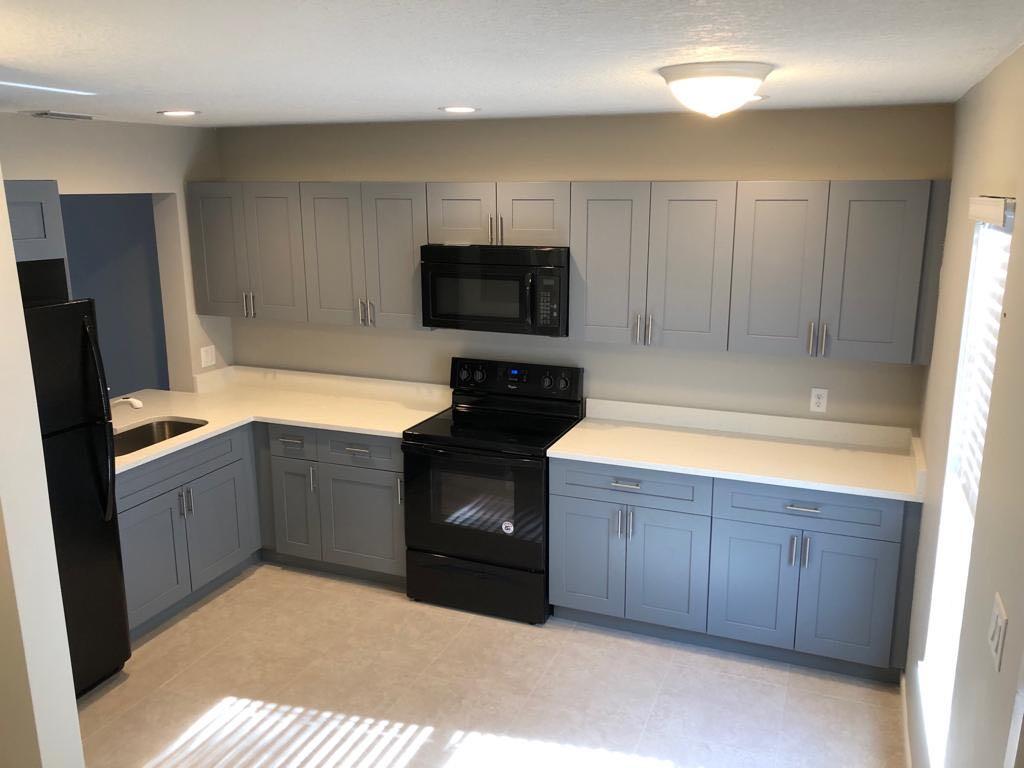 a kitchen with a refrigerator and a stove top oven