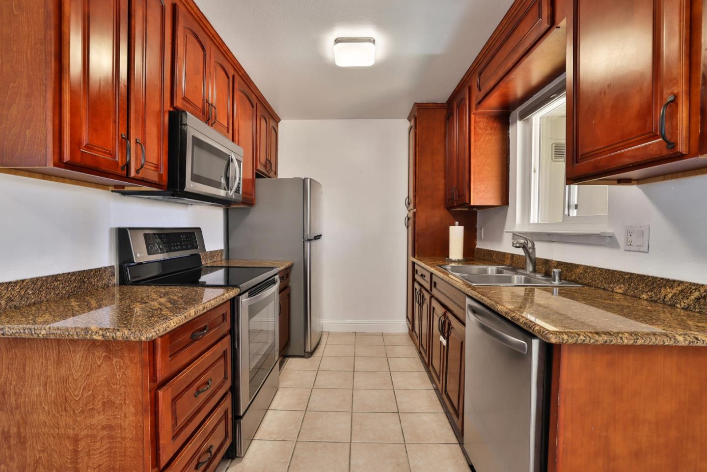 a kitchen with stainless steel appliances granite countertop a stove a sink and a refrigerator