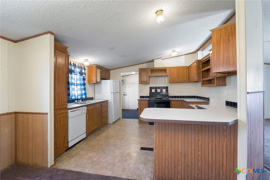 a kitchen with stainless steel appliances a refrigerator and a stove top oven